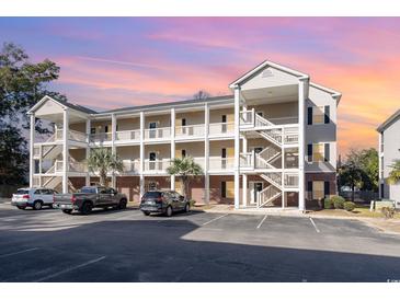 Two-story building exterior with parking and surrounding landscape at 1058 Sea Mountain Hwy. # 1-303, North Myrtle Beach, SC 29582
