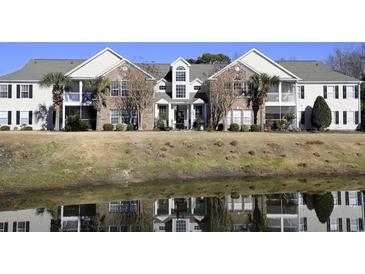Beautiful two-story home with brick facade, lots of windows, and reflected in a pond at 4657 Fringetree Dr. # C, Murrells Inlet, SC 29576