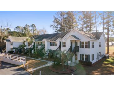 Well-maintained condo building with palm trees, green stairways, and white wooden siding at 820 Fairway Dr. # 1605, Longs, SC 29568