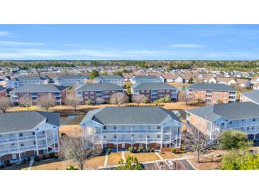 Aerial view of a community featuring multiple buildings with a pond at 3923 Gladiola Ct. # 301, Myrtle Beach, SC 29588