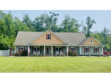 Charming single-story home featuring a well-manicured lawn, rocking chairs and a welcoming front porch at 640 Fox Hollow Rd., Murrells Inlet, SC 29576