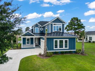 Two-story blue house with white accents, two-car garage, and landscaped lawn at 1103 Bluffton Ct., Myrtle Beach, SC 29579