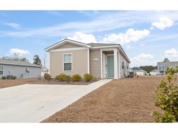 One-story house with light brown siding, a green door, and a concrete driveway at 405 Toledo St., Conway, SC 29526