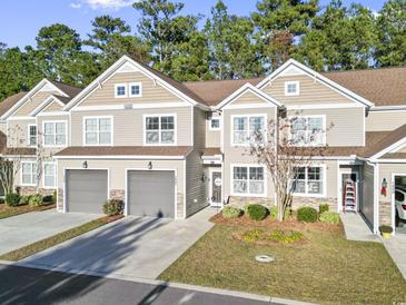 Tan siding two-story townhome with two-car garage and landscaping at 100 Machrie Loop # 17-C, Myrtle Beach, SC 29588