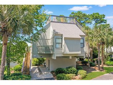 Elevated home with spacious deck, water views, and stairs leading to the entrance at 25 Frigate Ct., Pawleys Island, SC 29585