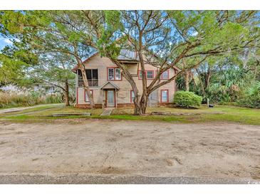 Two-story beach house with screened porch and mature landscaping at 298 Myrtle Ave., Pawleys Island, SC 29585