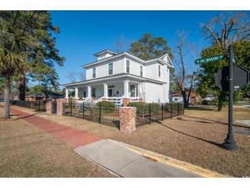 Two-story white house with black fence and brick pillars at 301 North Main St., Hemingway, SC 29554