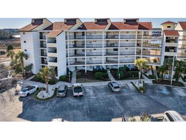 Aerial view of a multi-story building with parking and water access at 4390 Bimini Ct. # 208, Little River, SC 29566