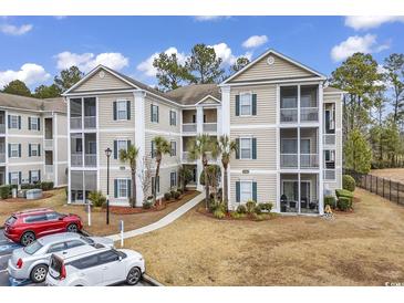 Inviting condo building with multiple stories, manicured landscaping, and ample parking at 242 Sun Colony Blvd. # 303, Longs, SC 29568