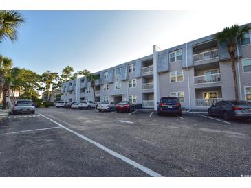 Exterior view of a light-grey building with ample parking at 401 N Hillside Dr. # 3C, North Myrtle Beach, SC 29582