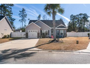 Charming single-story home with a well-manicured front yard, palm tree, and a paved driveway leading to a two-car garage at 160 Maggie Way, Myrtle Beach, SC 29588