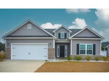 Gray house with white garage door and landscaping at 456 Hayloft Circle, Conway, SC 29526