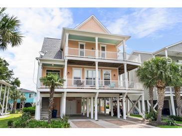 Charming raised beach home featuring double balconies, ground floor parking, and beachside access at 504 21St Ave. N, North Myrtle Beach, SC 29582