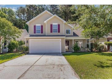 Two-story house with beige siding, attached garage, and manicured lawn at 1247 Brighton Ave., Myrtle Beach, SC 29588