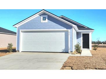 Newly built home featuring a light blue exterior, white garage door, and black front door at 436 Ribbon Rail Way, Loris, SC 29569