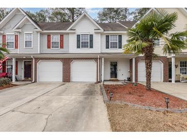 Townhouse exterior featuring brick facade, two-car garage, and landscaping at 629 Riverward Dr. # 629, Myrtle Beach, SC 29588