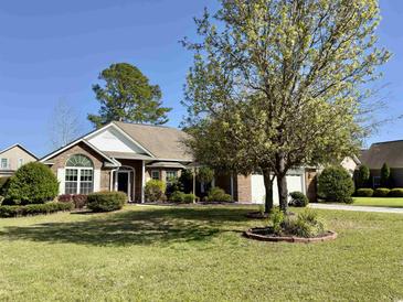 Brick house with a two-car garage and well-manicured lawn at 635 Bucks Trail, Longs, SC 29568