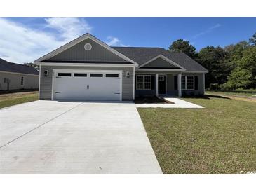 Newly constructed home with gray siding, white garage door, and landscaped lawn at 8183 Kerl Rd., Conway, SC 29526