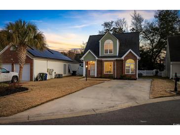 Brick home with attached garage and landscaped yard at 1023 Marthas Way, North Myrtle Beach, SC 29582