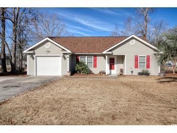 One-story house with attached garage, red accents, and a well-maintained lawn at 104 Osprey Cove Loop, Myrtle Beach, SC 29588