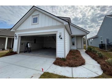 Charming single-Gathering home showcasing a two-car garage and a well-manicured front yard with green grass at 1273 Lady Bird Way, North Myrtle Beach, SC 29582