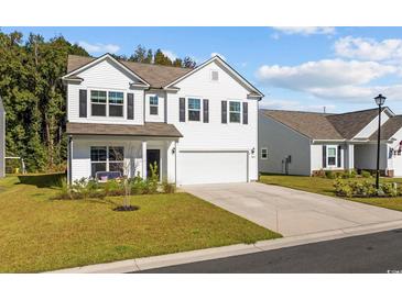 Charming two-story home featuring white siding, black shutters, manicured lawn, and attached two-car garage at 2871 Ellesmere Circle, Myrtle Beach, SC 29579