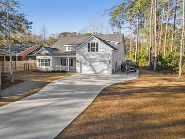 Two-story home with white siding, large windows, and a spacious driveway at 34 Pipedown Way, Pawleys Island, SC 29585