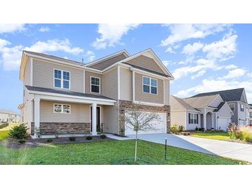 Two-story house with beige siding, stone accents, and a two-car garage at 382 Glacier Way, Conway, SC 29526