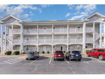 Three-story building with brick and siding, ample parking, and a landscaped area at 4781 Wild Iris Dr. # 304, Myrtle Beach, SC 29577