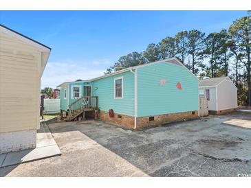 Charming teal home with brick base and small front porch at 703 3Rd Ave. S, North Myrtle Beach, SC 29582