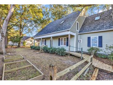 Two-story house with gray siding, walkway, and garden at 101 Bent Tree Ln., Pawleys Island, SC 29585