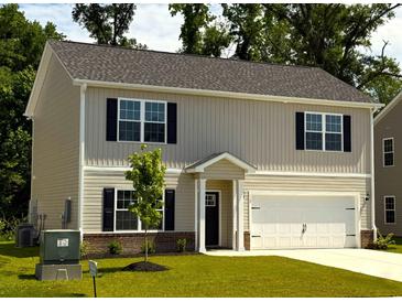 Charming two-story home featuring a well-maintained lawn and attached two-car garage at 112 Lakota Loop, Longs, SC 29568