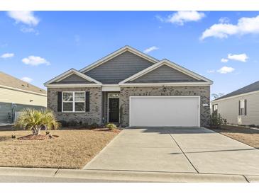 Brick and gray siding house with a two-car garage and landscaping at 1164 Maxwell Dr., Little River, SC 29566