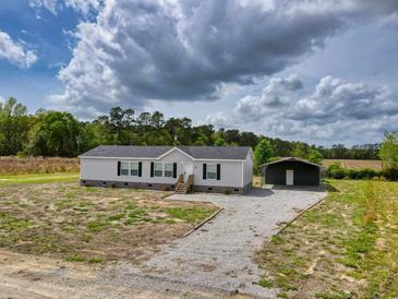 Charming single-story home with gravel driveway and separate covered storage at 122 Willie Mays Pl., Aynor, SC 29511