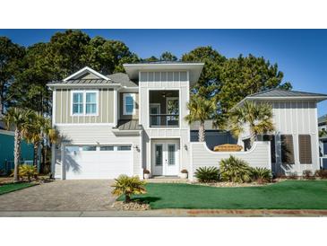 Two-story Craftsman home with a neutral color palette, white trim, and a landscaped yard at 132 Serenity Point Dr., Little River, SC 29566