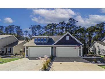 Exterior of charming two-story home with double garage and landscaped yard at 1420 Jardine Loop, Little River, SC 29566