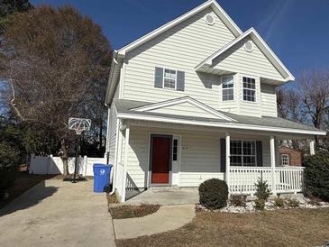 Two-story house with a red door, basketball hoop, and small yard at 1674 Citadel Ln., Myrtle Beach, SC 29577