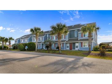 Front view of townhouses with palm trees and a paved road at 1851 Colony Dr. # 5E, Surfside Beach, SC 29575