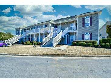 Exterior view of gray townhomes featuring white stairs, trim, and shutters at 213 Wando River Rd. # 11-G, Myrtle Beach, SC 29579