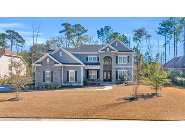 Two-story house with gray siding, stone accents, and a landscaped lawn at 2560 Ellerbe Circle, Myrtle Beach, SC 29588