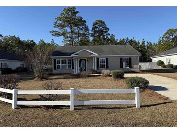 Cute ranch home with a landscaped lawn and white picket fence at 2958 Mary Hines Ln., Georgetown, SC 29440