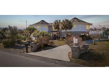 Two-story house with circular design, brick exterior, and palm trees at 4552 River Rd., Little River, SC 29566