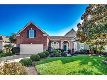 Brick home with a landscaped lawn and a two-car garage at 58 Long Creek Dr., Murrells Inlet, SC 29576