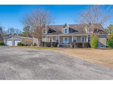 Single-story home with detached garage and spacious front yard at 6803 E Highway 19, Loris, SC 29569