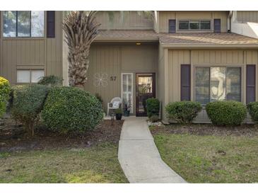 Inviting condo exterior with a well-maintained walkway and landscaping at 800 Egret Circle # 57, Little River, SC 29566