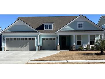 Charming one-story home with blue siding, a two-car garage, a well-maintained lawn, and lovely landscaping at 1310 Beautyberry Way, North Myrtle Beach, SC 29582