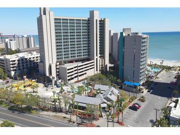 Aerial view of oceanfront resort, pool, playground, and parking at 201 74Th Ave. N # 701, Myrtle Beach, SC 29572