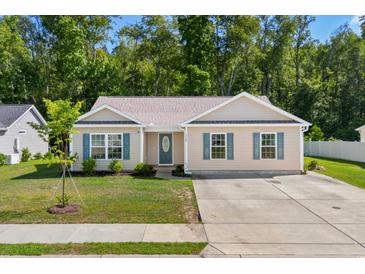 Beige house with teal shutters, driveway, and grassy yard at 3348 Merganser Dr., Conway, SC 29527