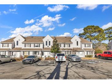 Front view of a light gray multi-unit building with parking at 500 Fairway Village Dr. # 1-O, Myrtle Beach, SC 29588