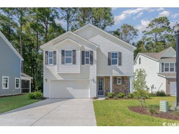 Two-story house with white siding, stone accents, and a two-car garage at 7015 Shooting Star Way, Myrtle Beach, SC 29579